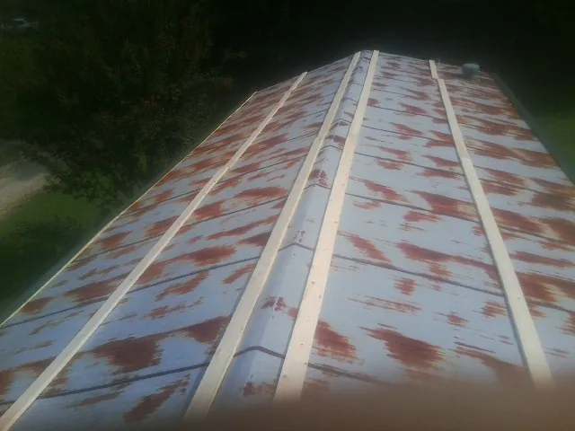 Rusted metal roof panels with new wood purlins before replacement — Storm Damage Roof Repair in Stoughton by Roofing Brothers